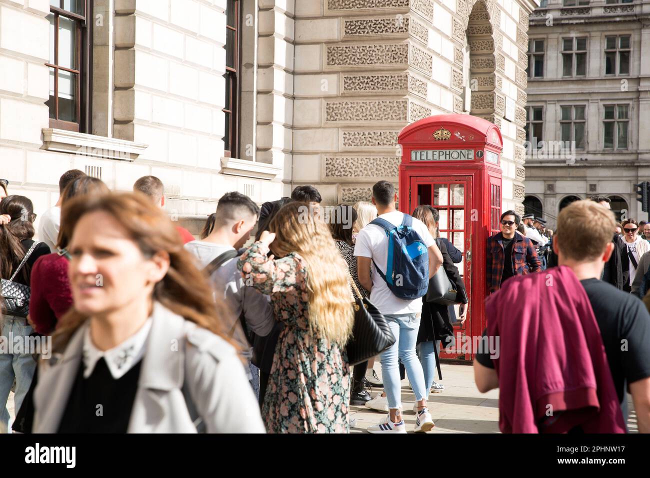 People queue to take photographs next to a red telephone box in ...