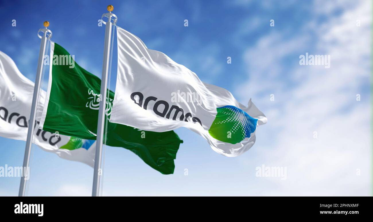 Dhahran, SA, march 2023: Flags of Aramco and Saudi Arabia waving on a clear day. Aramco is the Saudi national hydrocarbon company. Illustrative editor Stock Photo