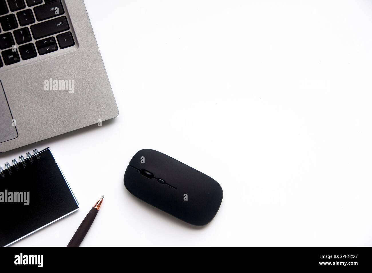 Top view of laptop, notepad and mouse on white cover background with