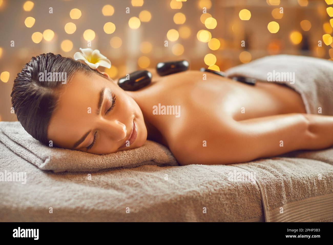 Young woman having hot stone massage in spa salon Stock Photo