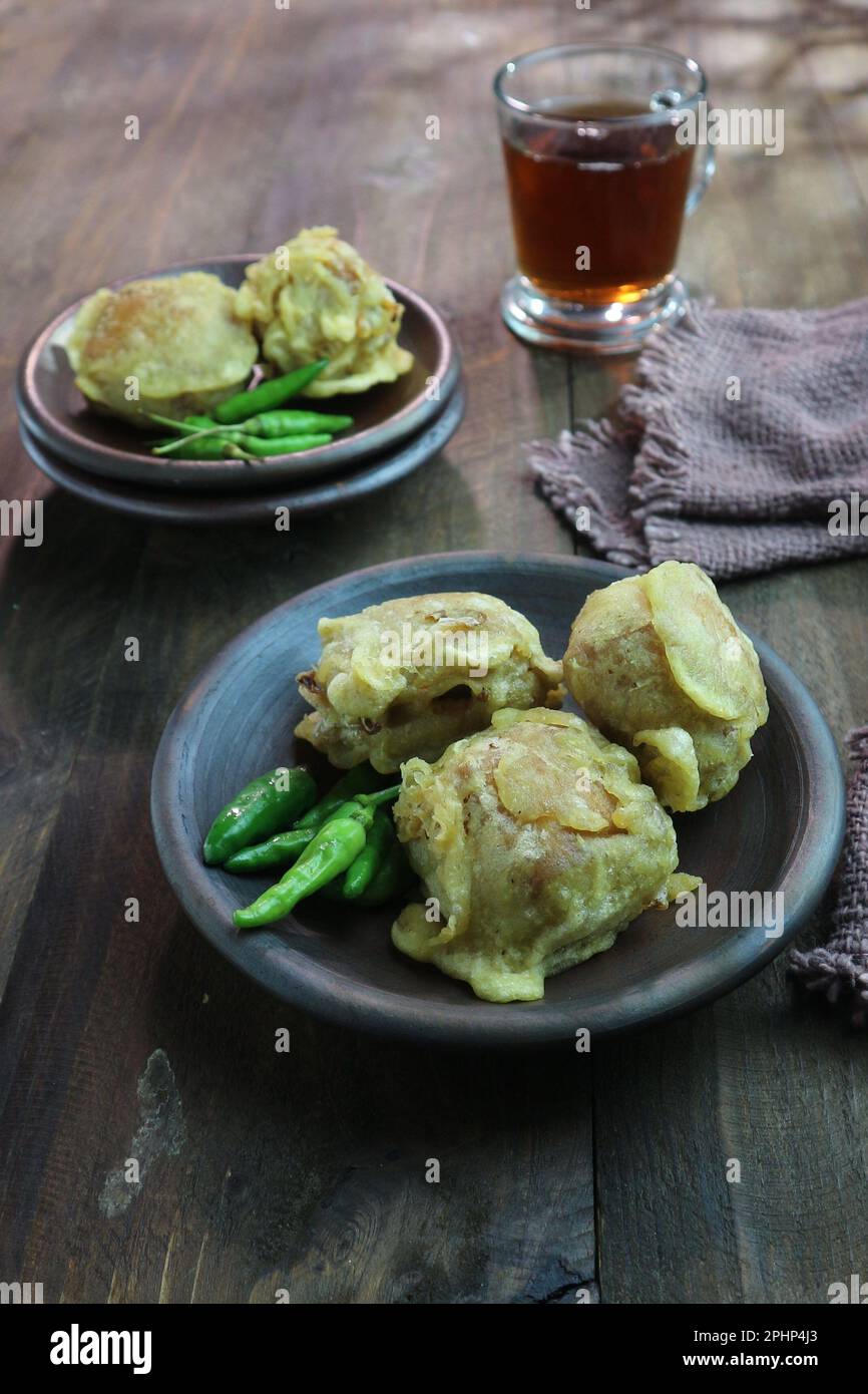 Flour fried tofu with green chilies in a clay plate served with a glass