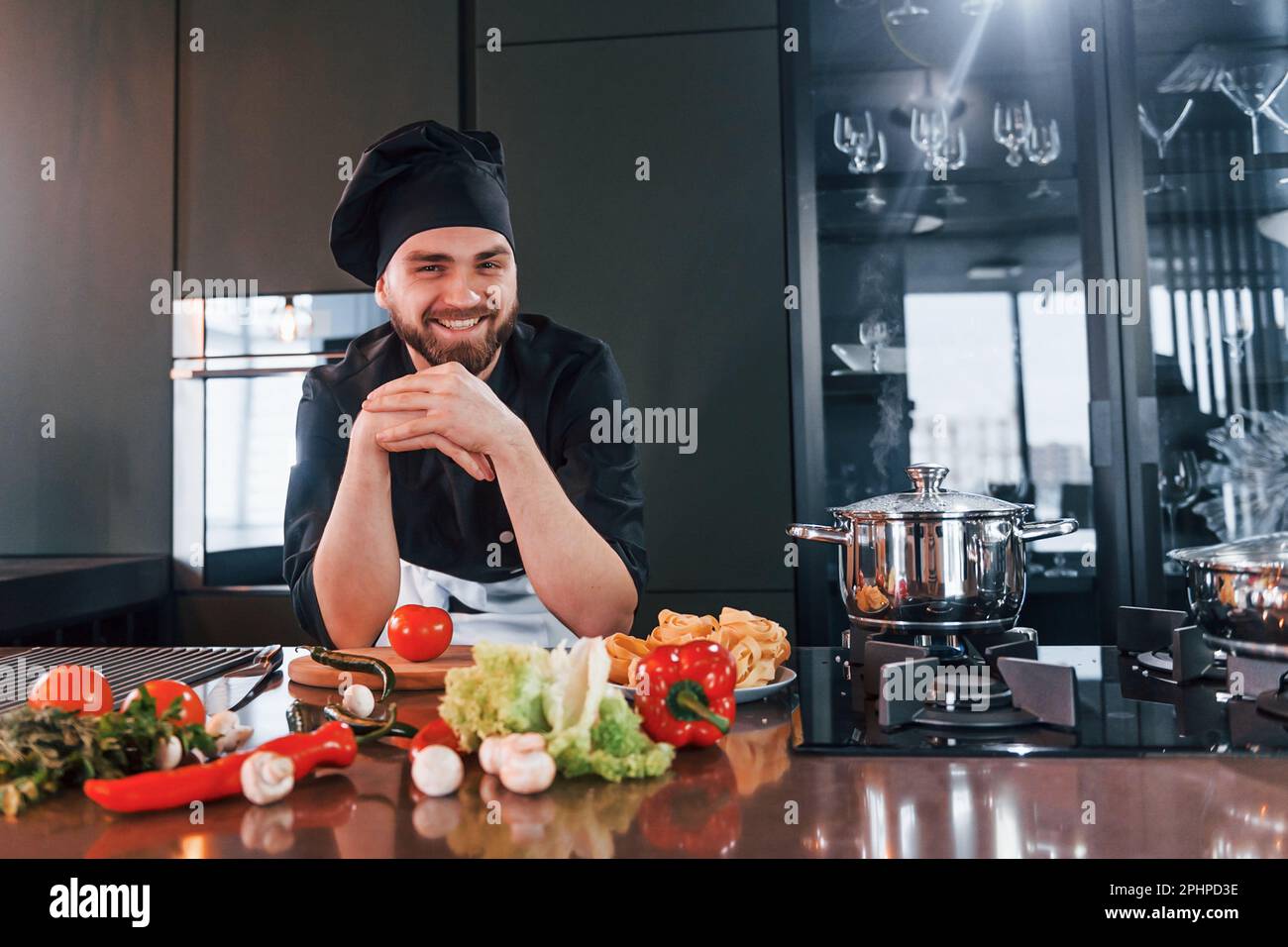 Preparing process. Professional young chef cook in uniform working on ...