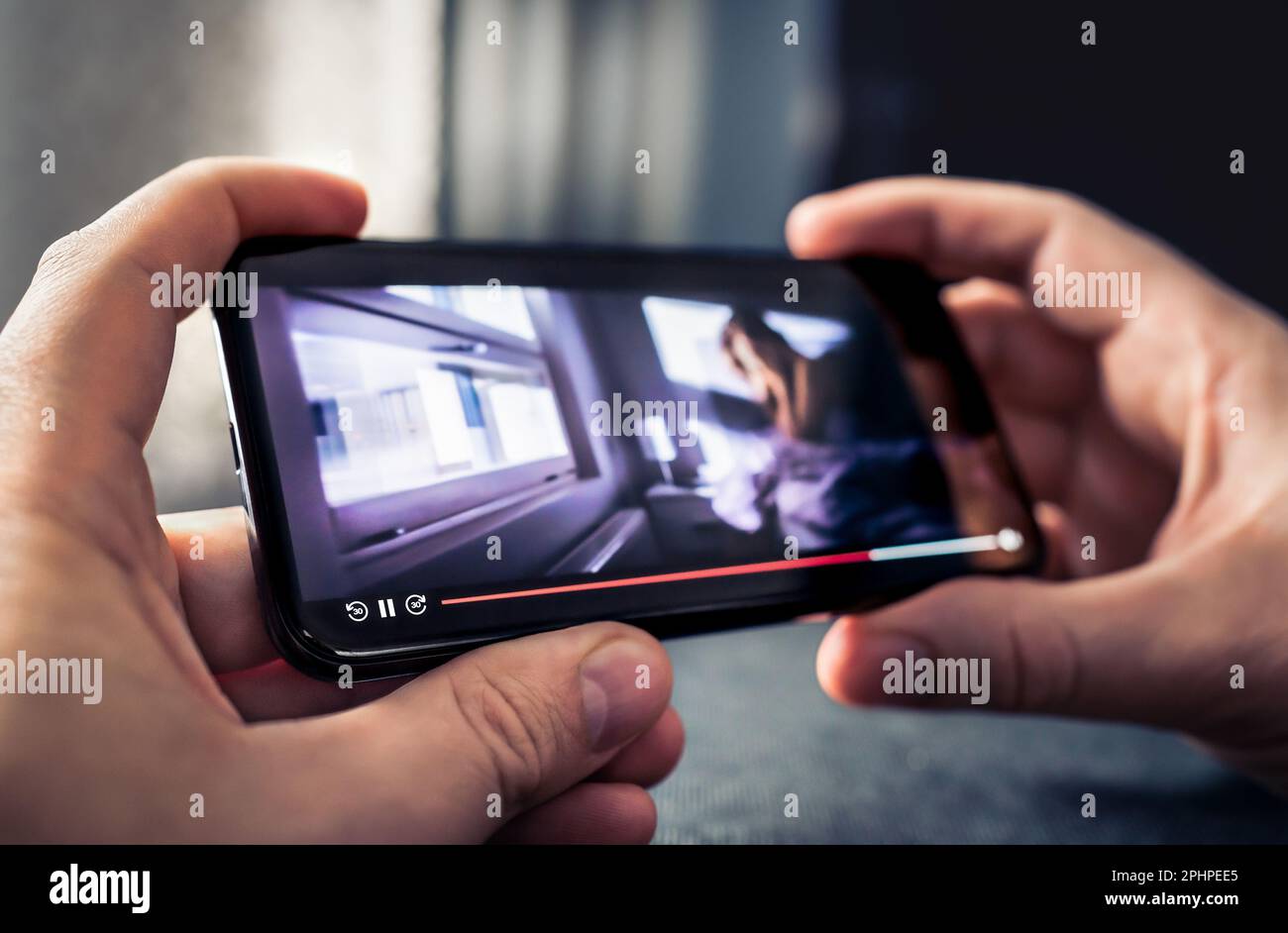 Movie stream and watching video with phone. Tv series in online VOD on demand service in smartphone screen. Multimedia player app mockup in cellphone. Stock Photo
