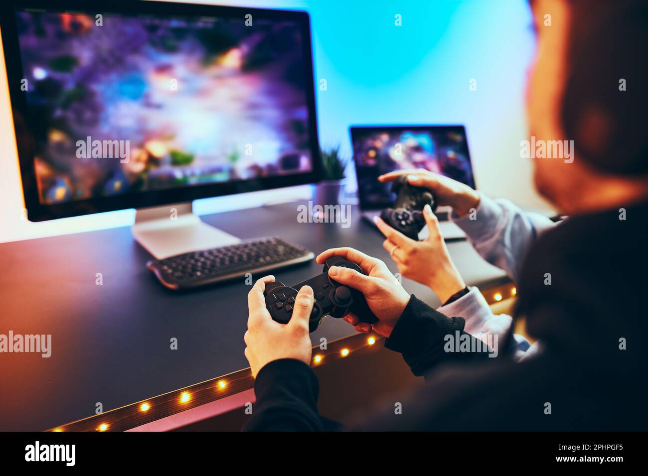 Friends playing video game at home. Gamers holding gamepads sitting at ...