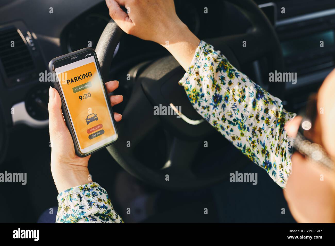 Woman using mobile parking app on smartphone. Driver using smartphone to pay for parking. Car park application on mobile phone. Convienience paying fo Stock Photo