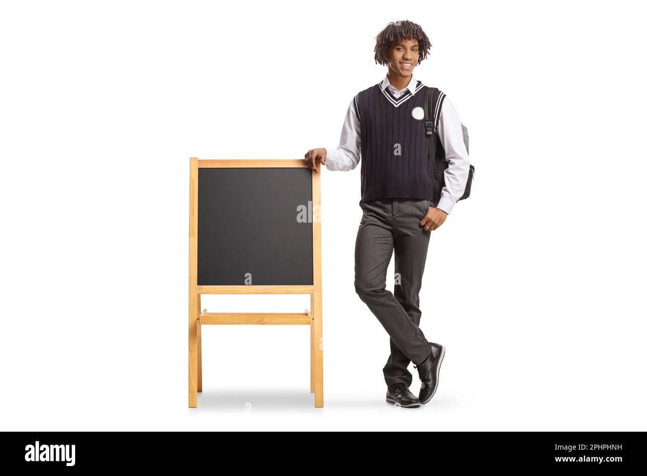 Full length portrait of a male african american student in a uniform leaning on blackboard isolated on white background Stock Photo