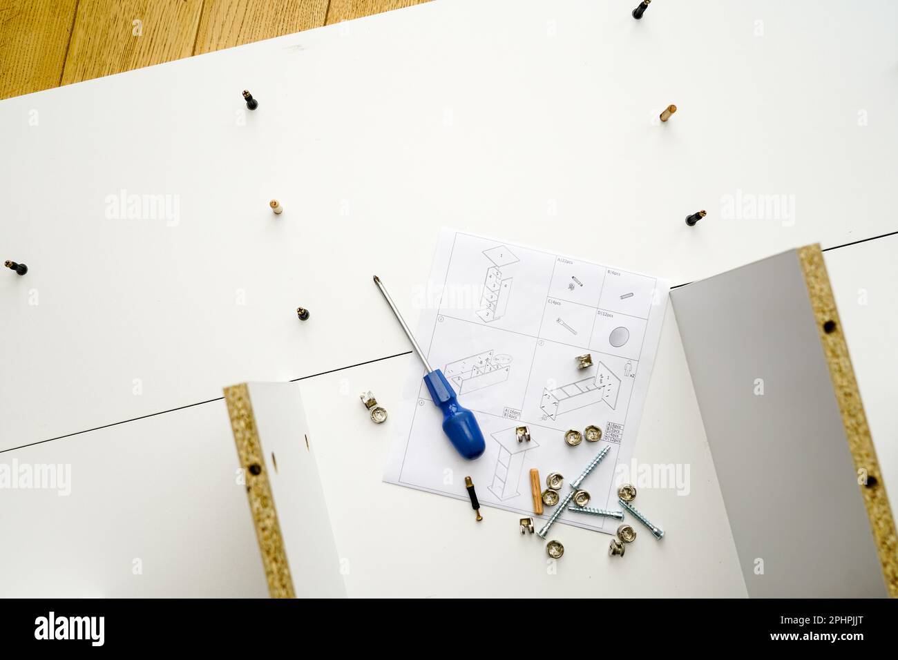 New white laminated chipboard furniture self mounting set with fitting screws, wooden pins