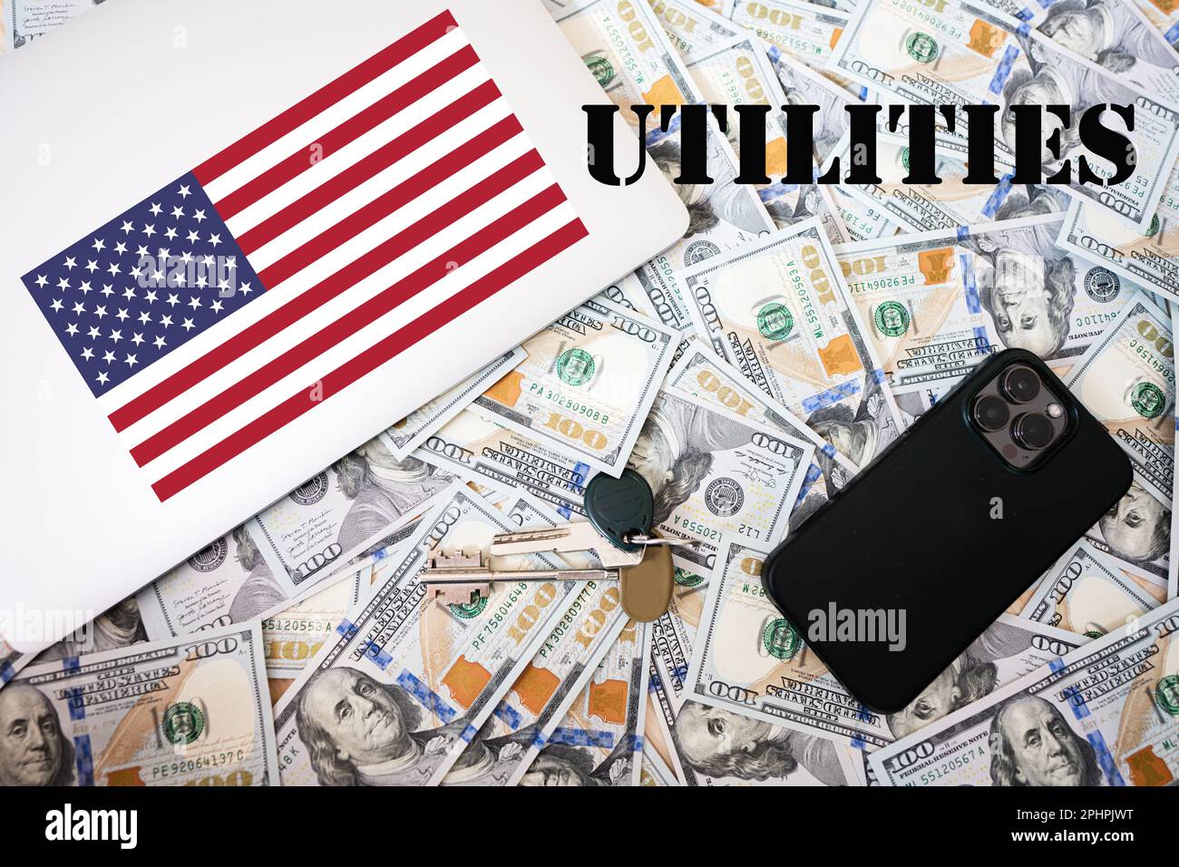 Utilities concept. USA flag, dollar money with keys, laptop and phone background. Stock Photo