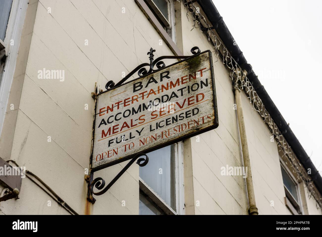 Sign outside a derelict hotel saying "Bar, Entertainment, Accommodation, Meals Served, Fully Licenced, Open to Non-Residents" Stock Photo