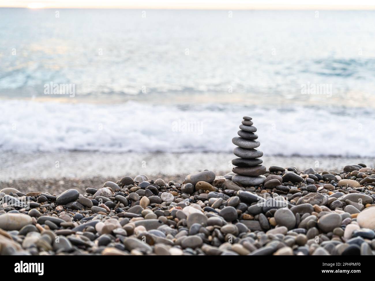 Stone pyramid. Pebbles balance pile, harmony zen stones, balance stack, sea pebble pyramid on shoreline, relaxation and peace concept Stock Photo