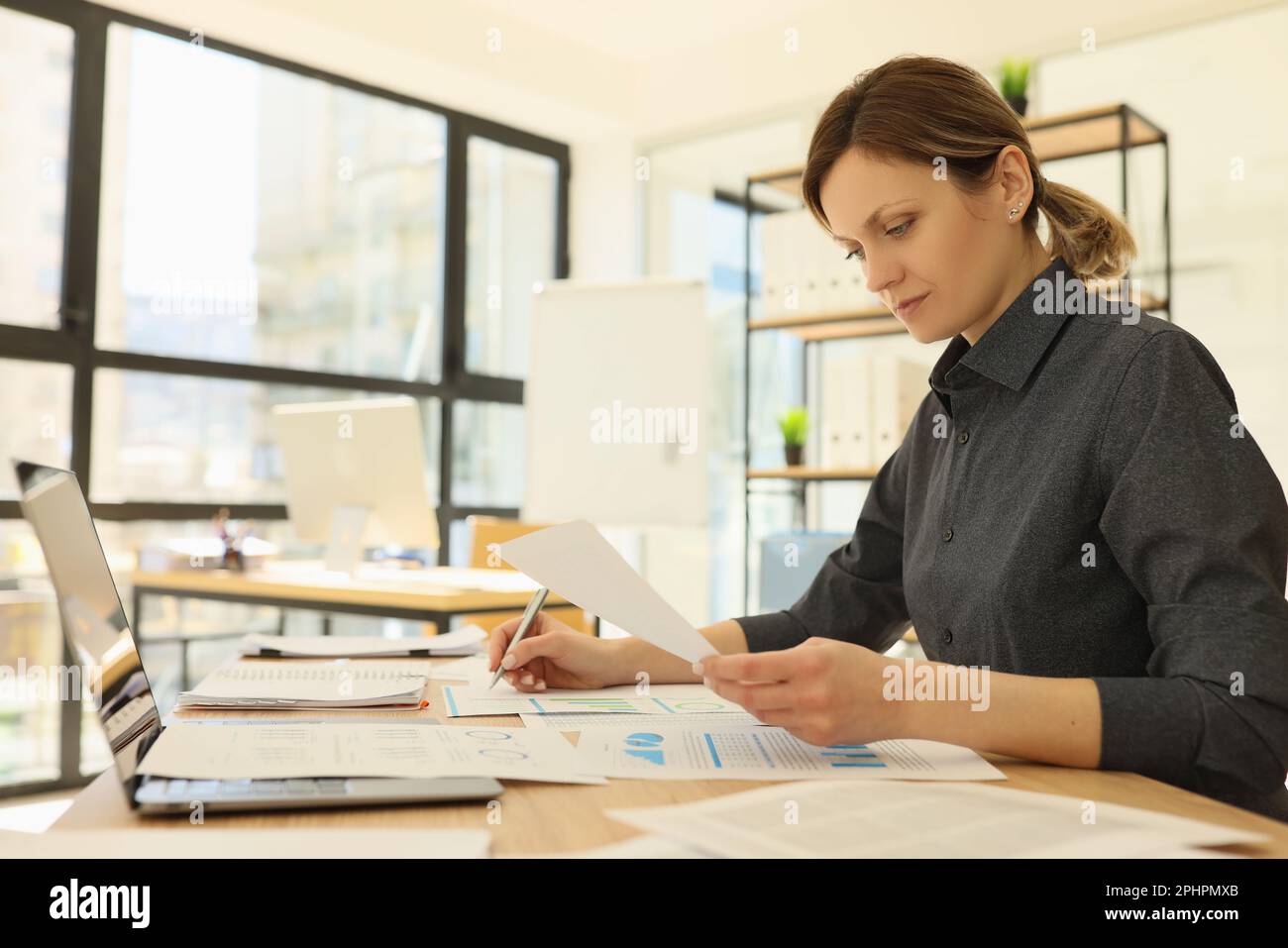 Focused employee makes notes while reading statistics papers Stock ...