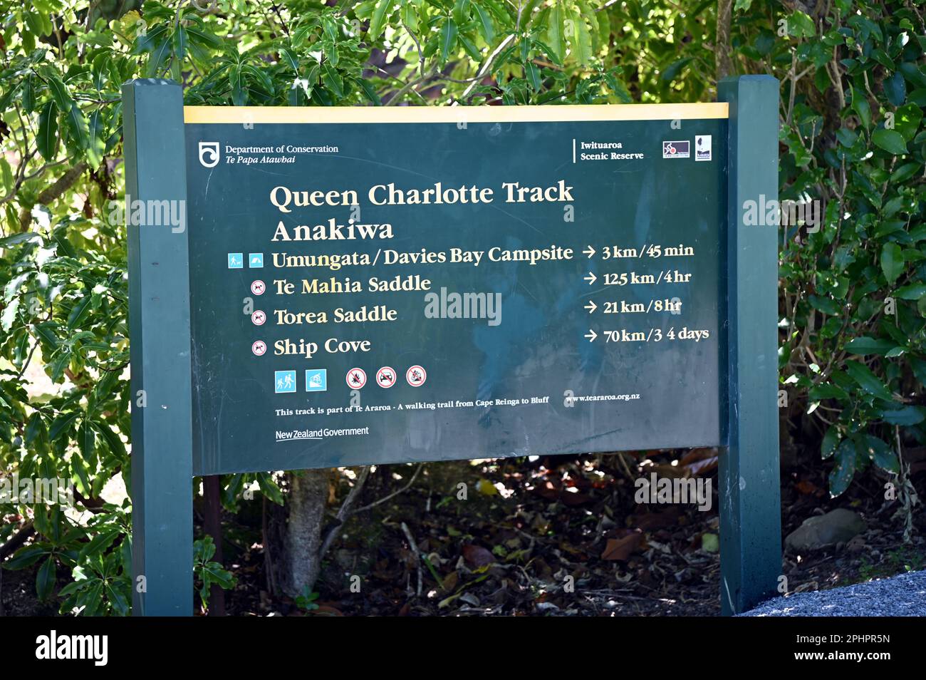 The Department of Conservation (DOC) sign at Anakiwa marking the start (or finish) of the 70+Km Queen Charlotte Track. The track ends at Ship Cove. Stock Photo