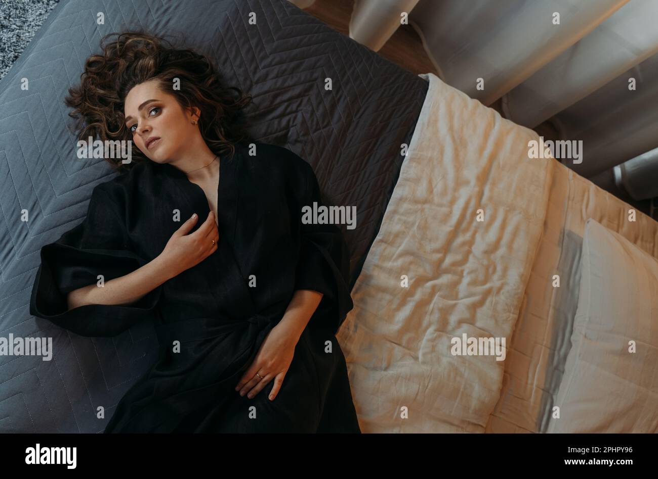 Happy beautiful young woman waking up after a healthy sleep, lying in a