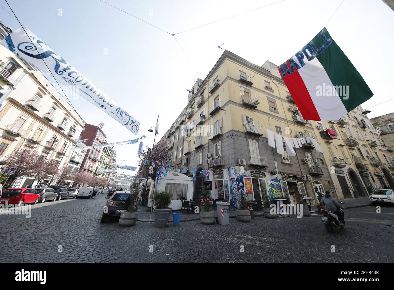 Naples, Italy. 22nd Mar, 2023. An Italian flag reading 'Napoli' (R) and other makeshift banners are displayed on a Naples street as the city prepares to win its potential first Scudetto in 33 years. - An incredible 19-point lead at the top of Serie A. Credit: Independent Photo Agency/Alamy Live News Stock Photo