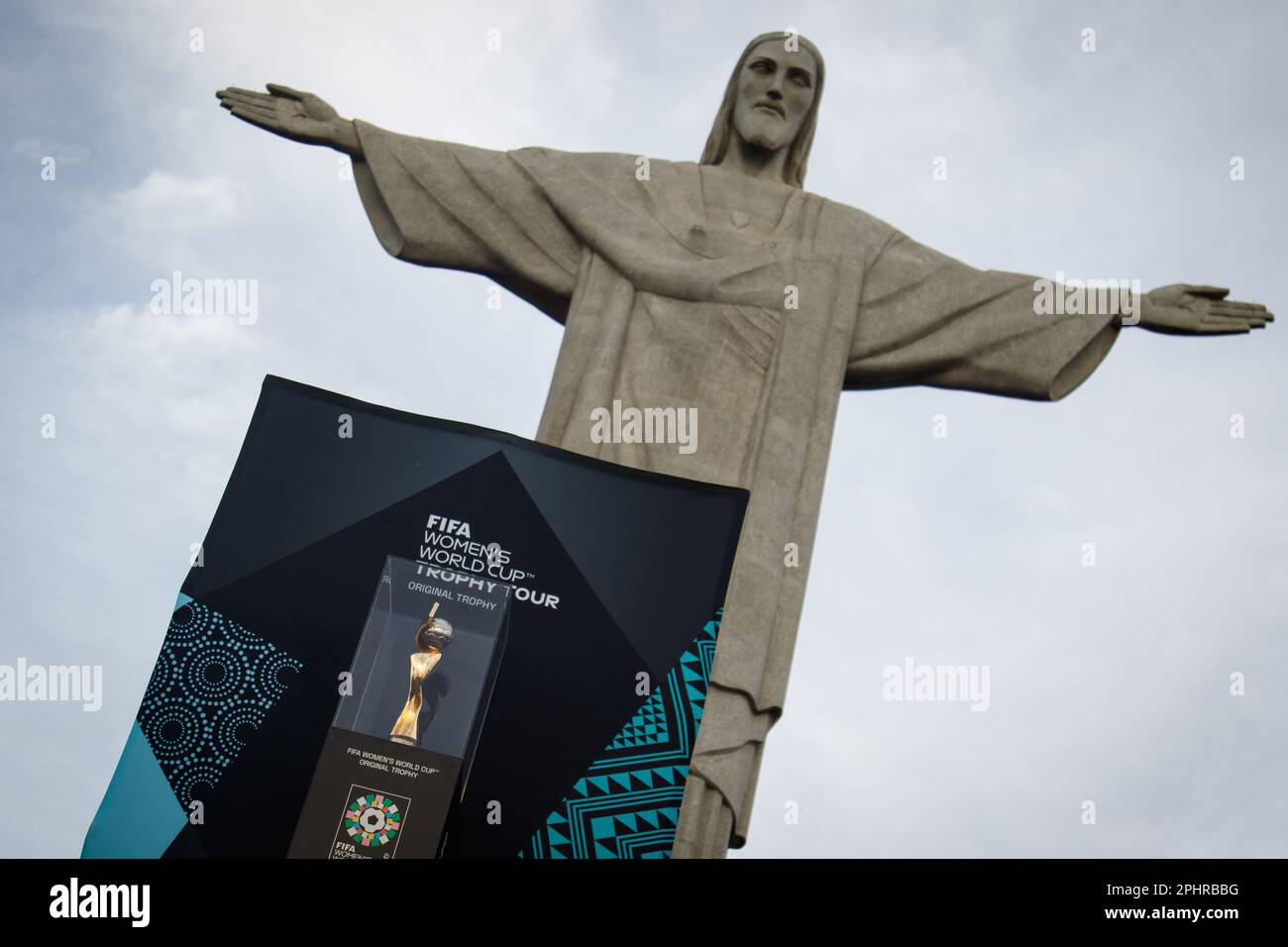 Rio De Janeiro, Brazil. 29th Mar, 2023. The FIFA Women's World Cup trophy stands at the foot of the statue of Christ The Redeemer. The tour of the trophy is intended to inspire people about women's soccer. The trophy visits the countries of the 32 participating teams. Credit: Joao Gabriel Alves/Joao Gabriel Alves/dpa/Alamy Live News Stock Photo