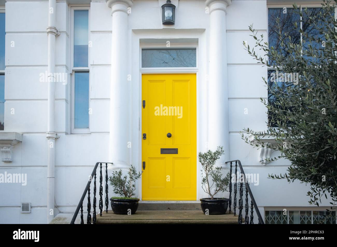 London- January 2023: A yellow door on a residential house in west London Stock Photo