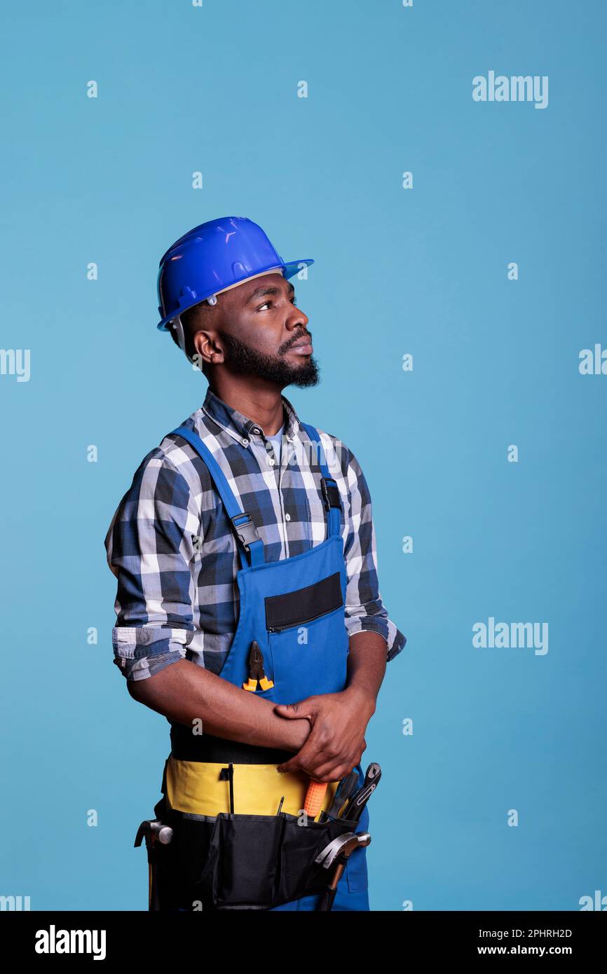 African american builder looking intently up, detailing the tools and materials needed to do the
