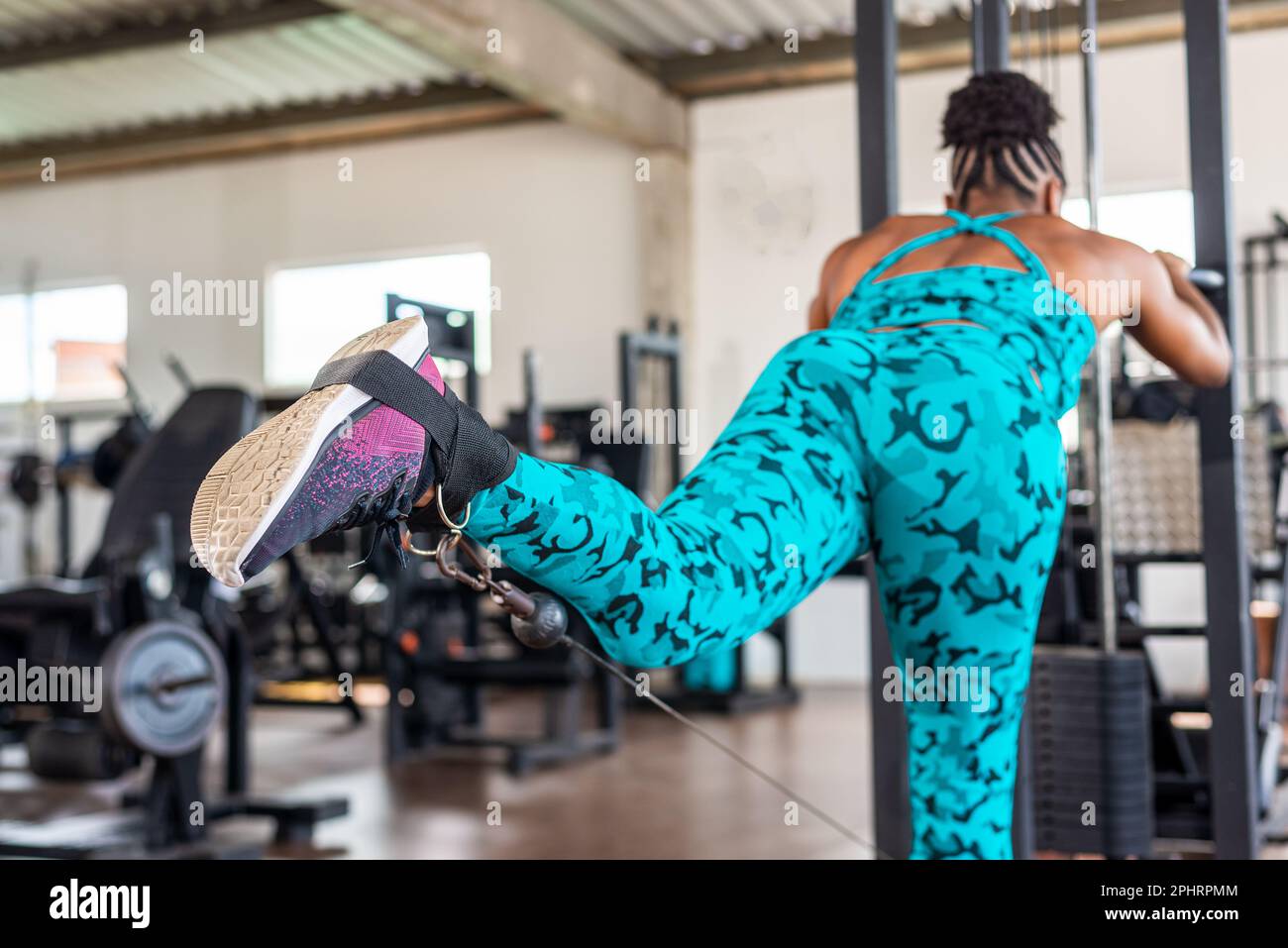 Beautiful woman training leg muscles on the pulley. Bodybuilding