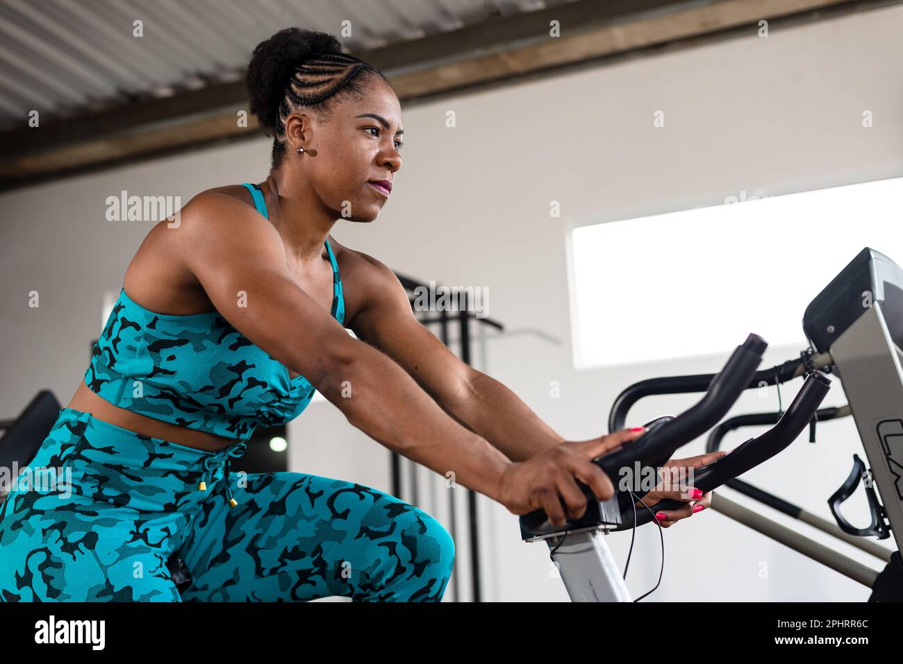 Pretty girl doing exercise on an exercise bike. crossfit gym. Cycling Stock  Photo - Alamy