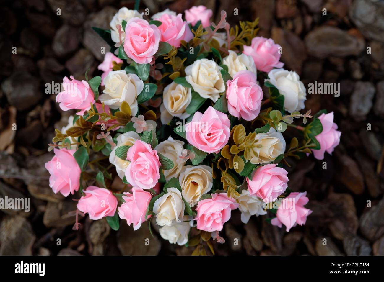 bouquet of artificial pink and beige roses seen from above against dark blurry ground Stock Photo