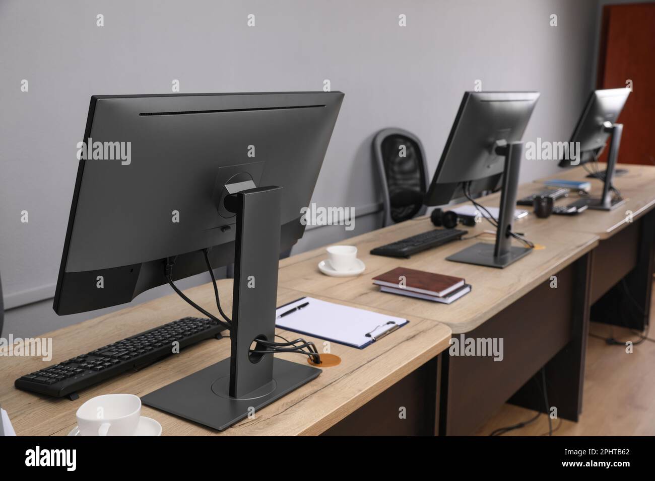 Open office interior. Modern workplaces with computers near light grey ...