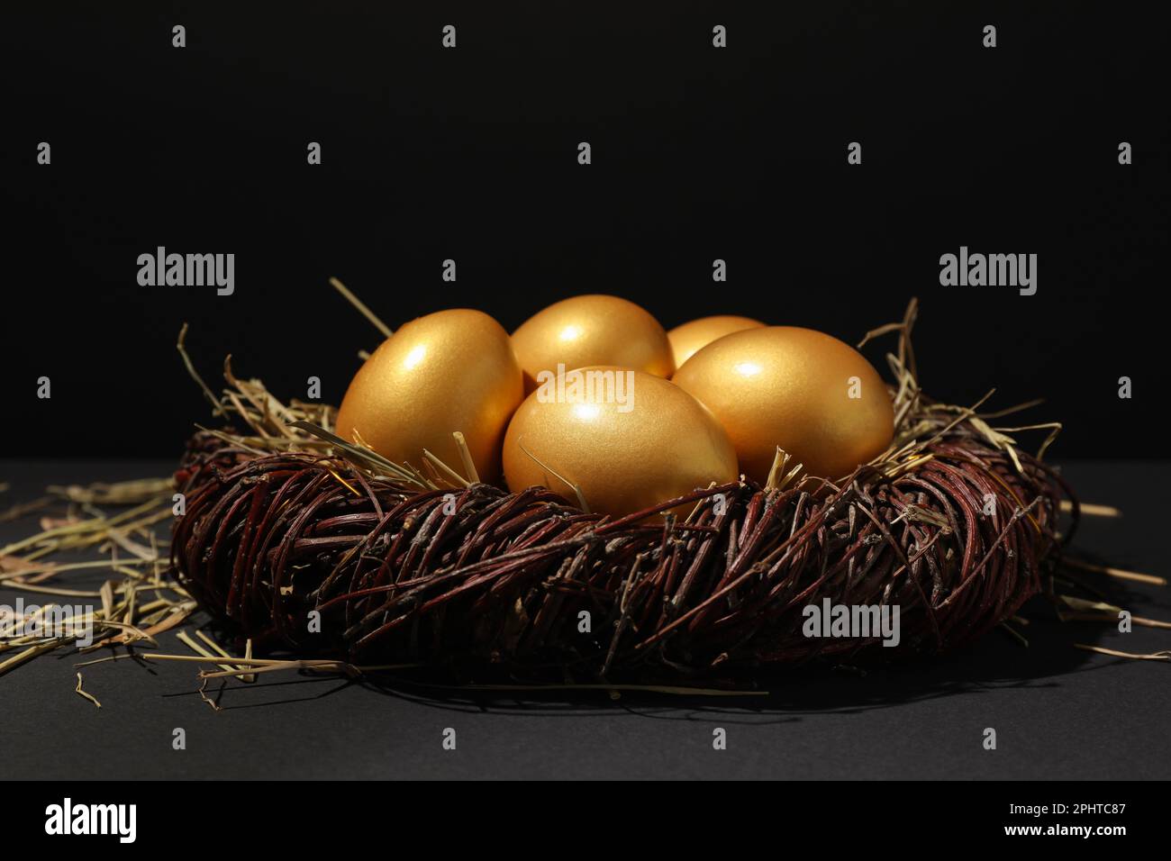 Shiny golden eggs in nest on black background Stock Photo - Alamy