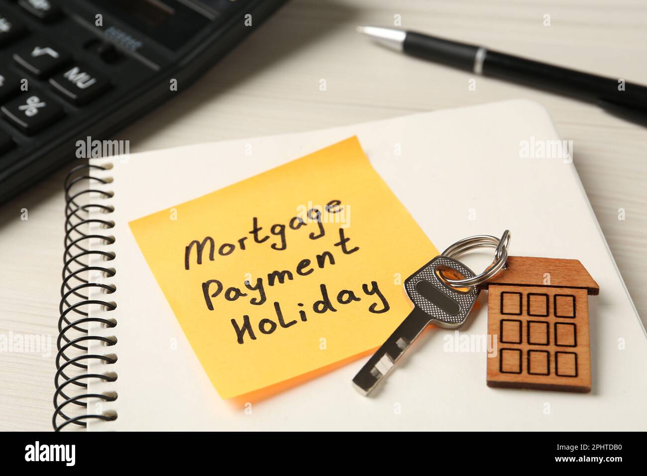 Paper note with words Mortgage Payment Holiday, key and notebook on