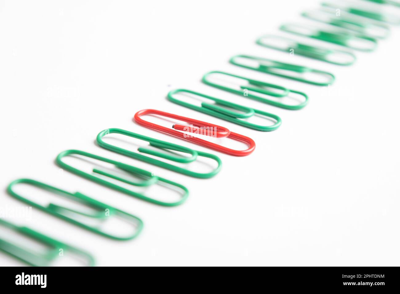 One red paperclip with all green paperclip, leader or unique concept