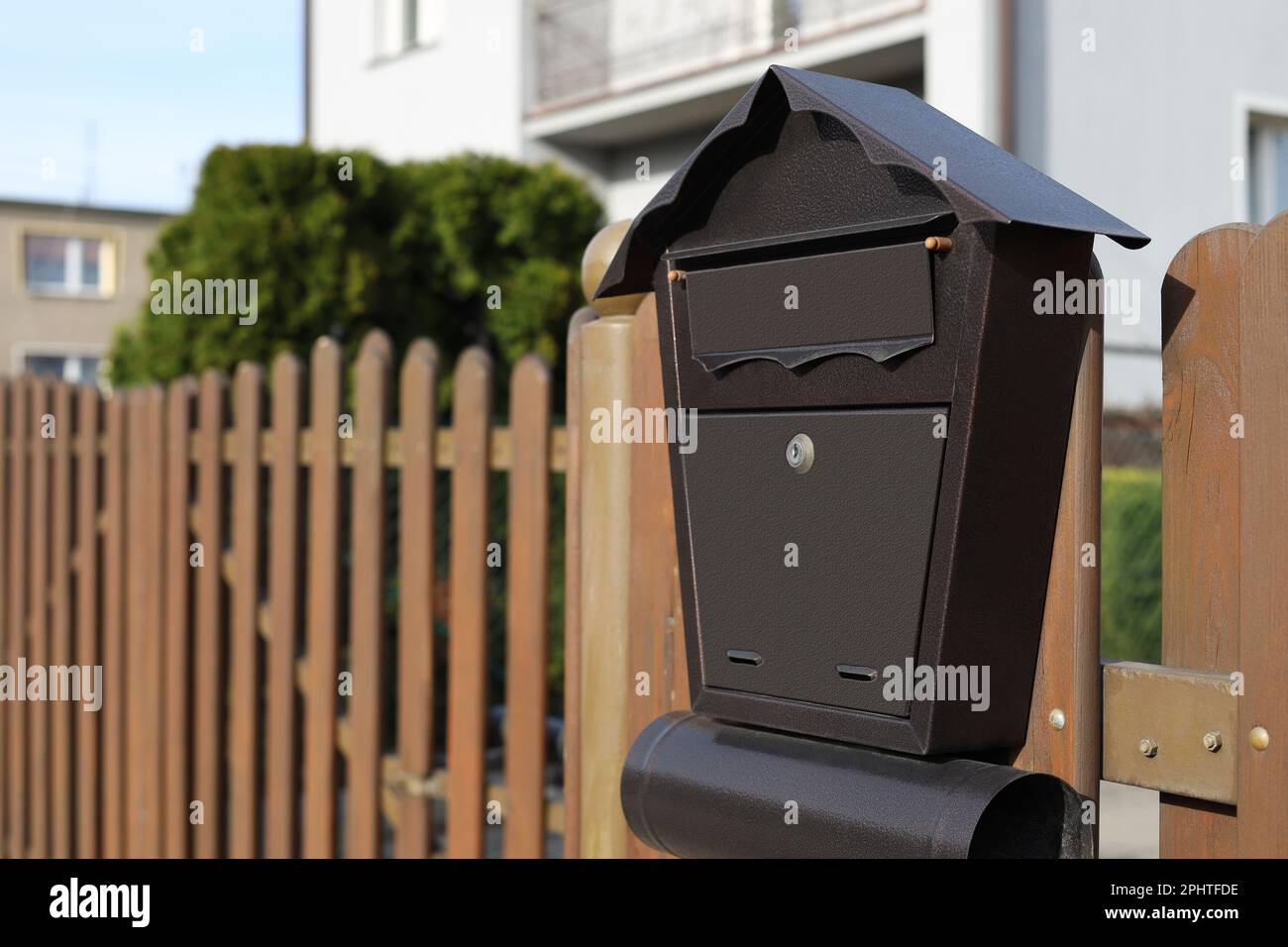 Beautiful house shaped mailbox with newspaper holder on wooden fence  outdoors, space for text Stock Photo - Alamy