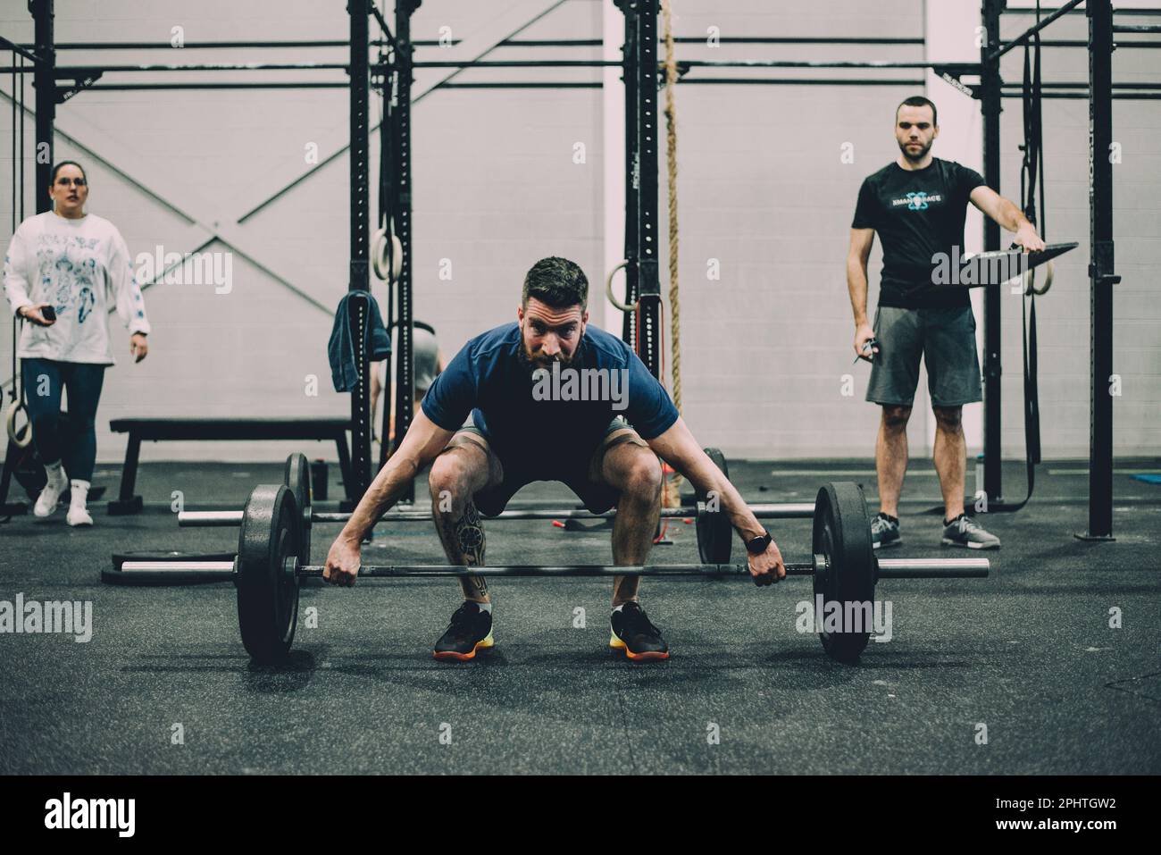 Fitness man lifting weights at crossfit gym in a squat position Stock