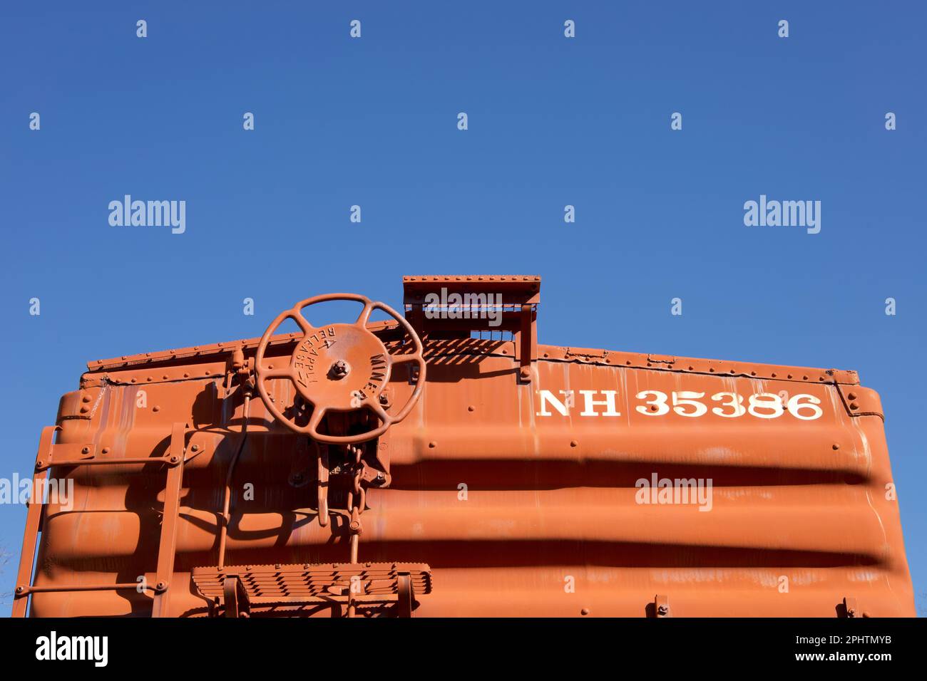 Haddam, Connecticut, USA: top of red railroad car with wheel and pipes.  Blue sky with copy space. Stock Photo