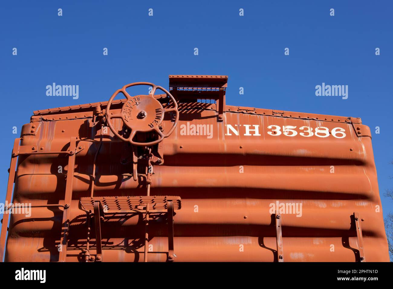 Haddam, Connecticut, USA: top of red railroad car with wheel and ladder.  Blue sky above. Stock Photo