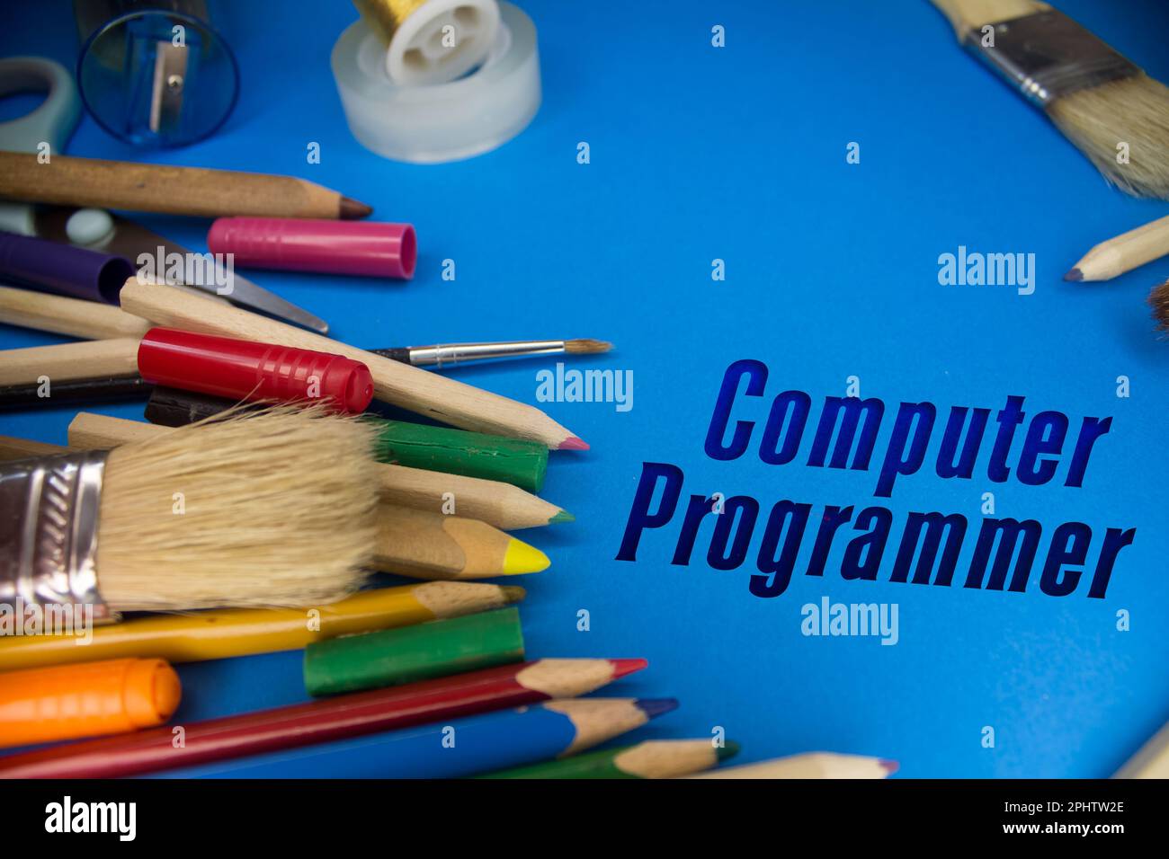 Overhead shot of school supplies with Computer Programmer text. Brushes, pencils, artistic tools. Art And Craft Work Tools. Stock Photo