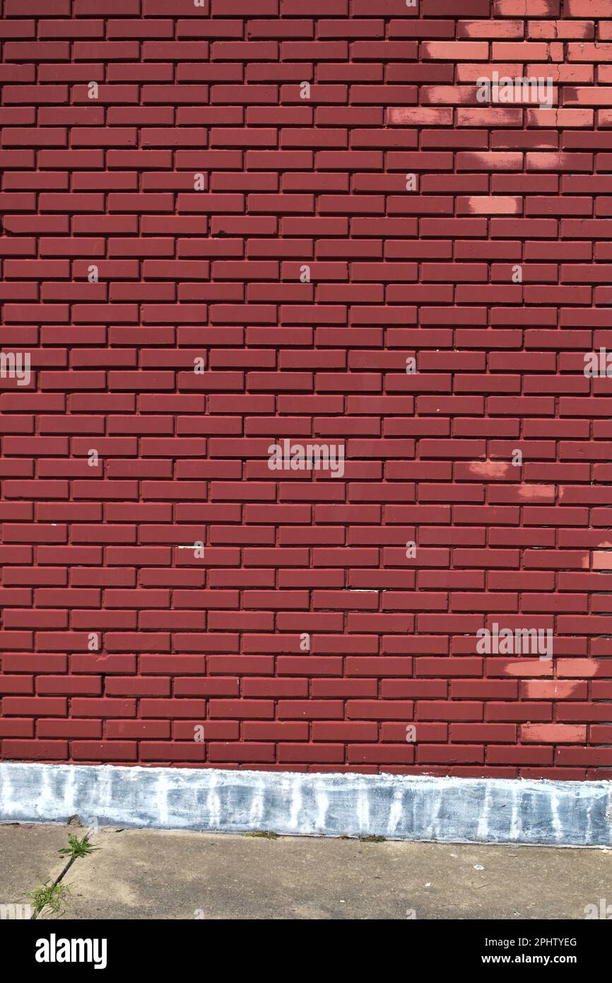 Solid red brick wall pink spots sidewalk Stock Photo Alamy