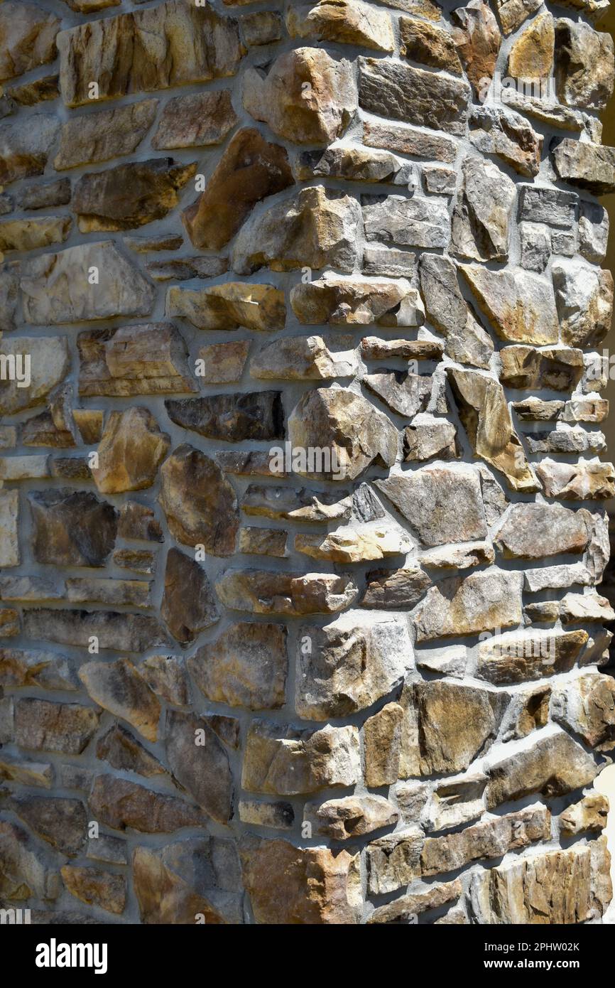 Large stone and mortar rock column sunny side Stock Photo