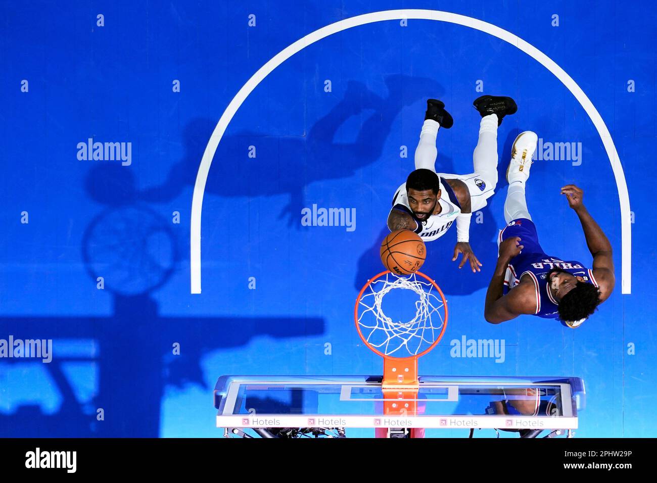 Dallas Mavericks' Kyrie Irving, left, goes up for a shot against  Philadelphia 76ers' Joel Embiid during the second half of an NBA basketball  game, Wednesday, March 29, 2023, in Philadelphia. (AP Photo/Matt