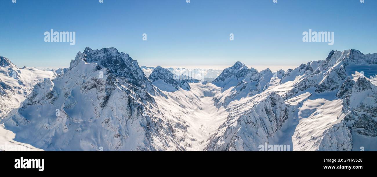 Mountain peaks covered in snow under a clear blue sky Stock Photo - Alamy