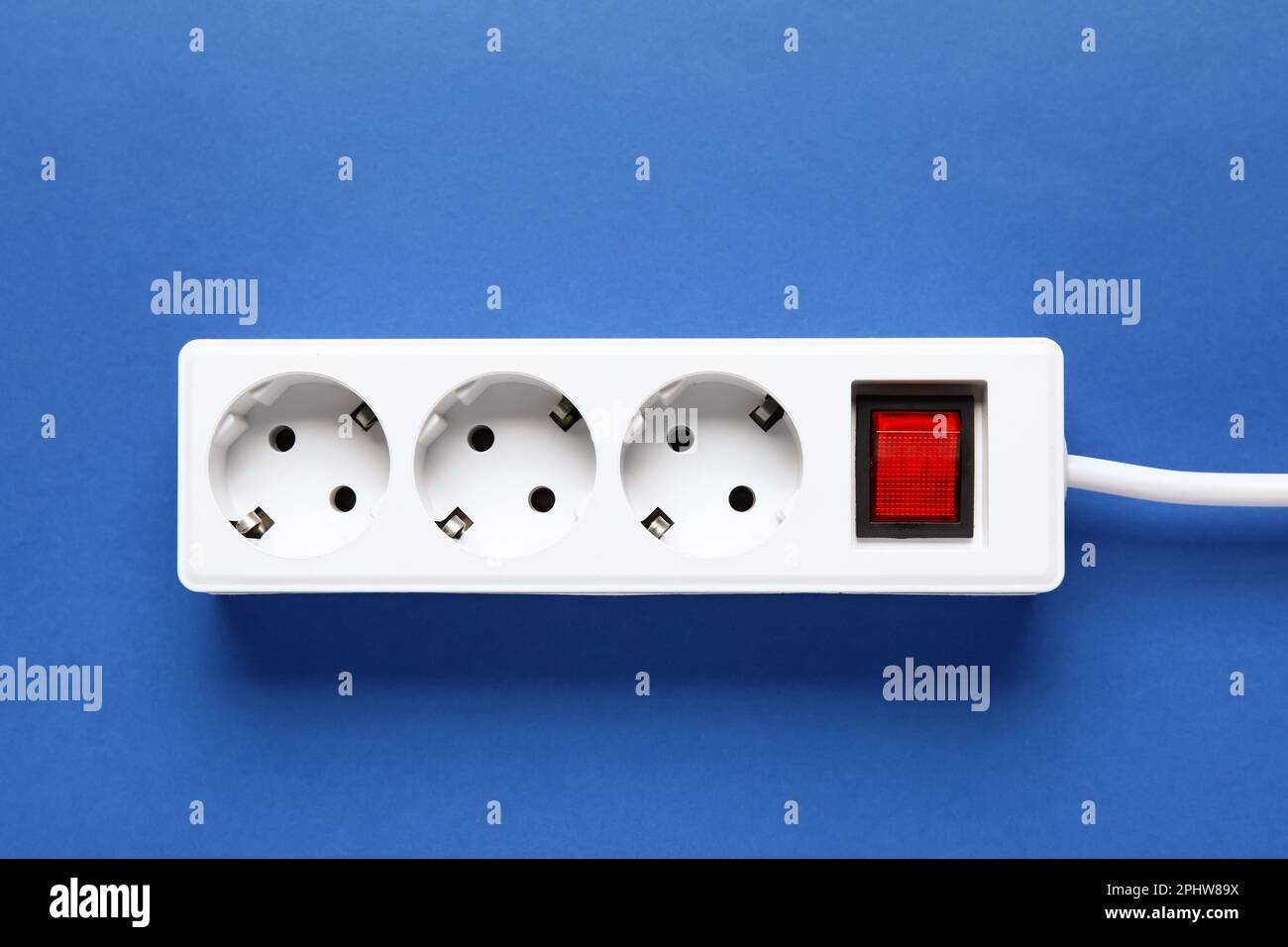 Electric extension cord on blue background Stock Photo