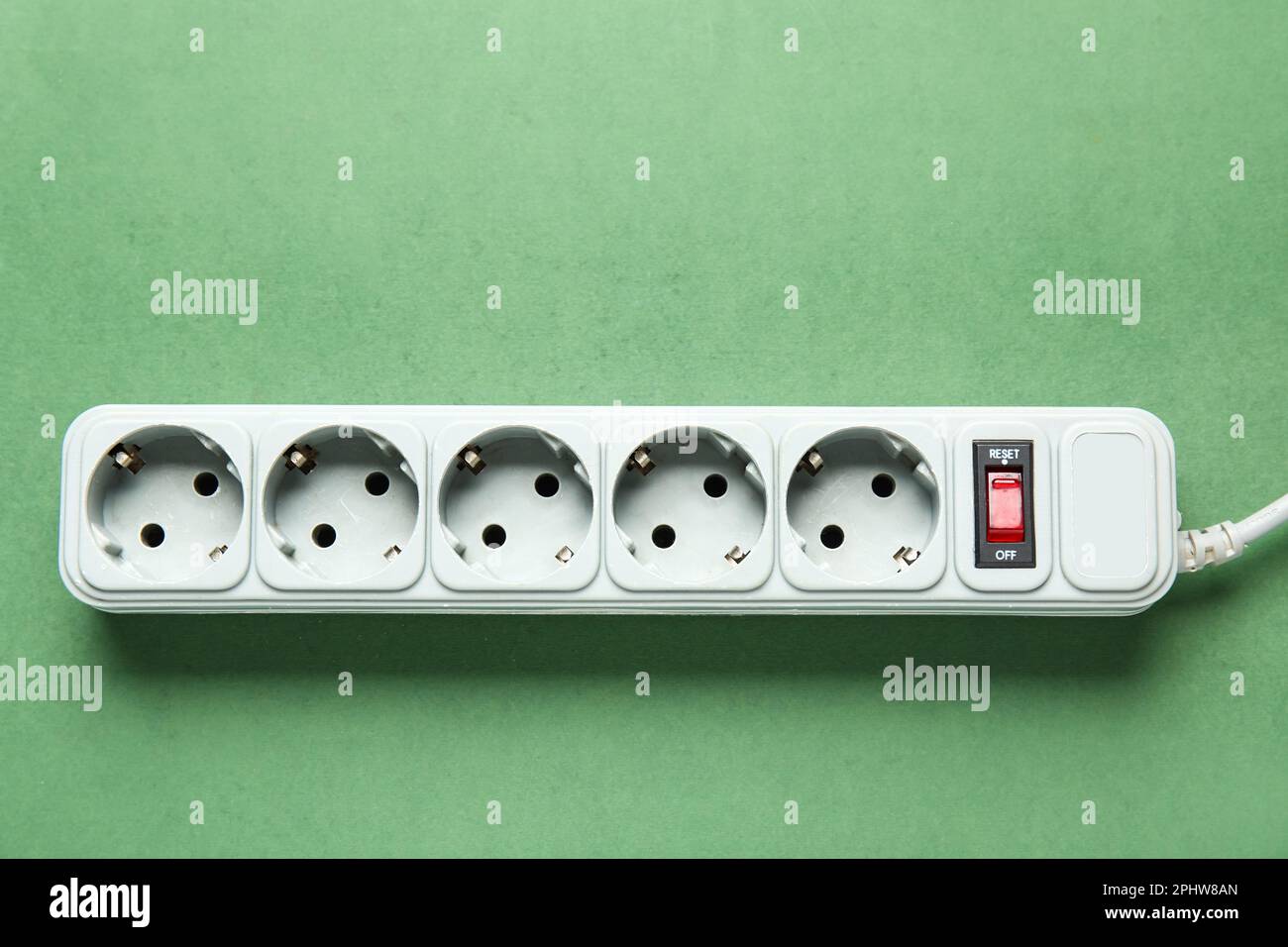 Electric extension cord on green background Stock Photo