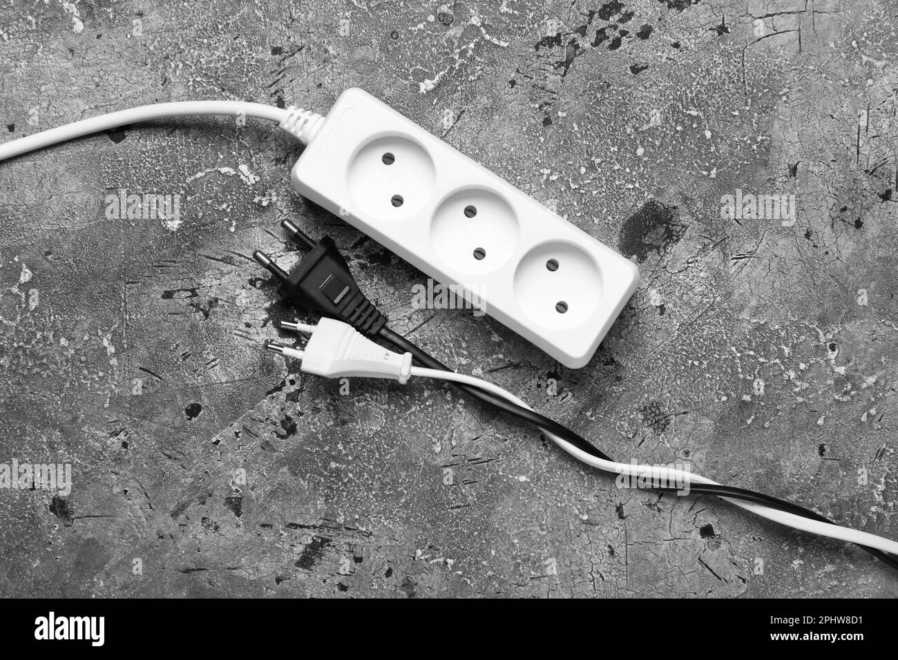 Electric extension cord and plugs on grey grunge background Stock Photo