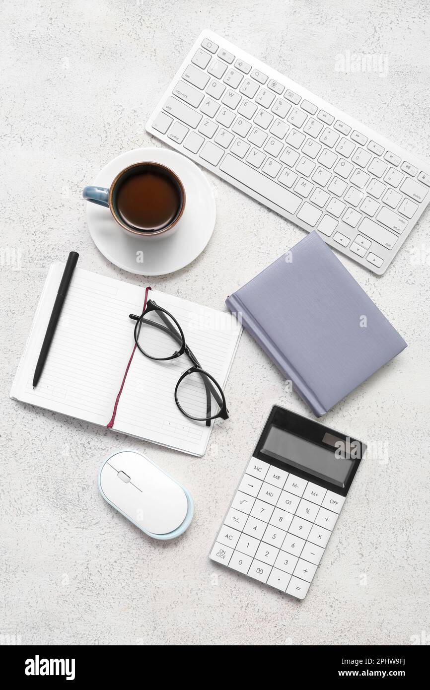 Composition with eyeglasses, blank notepad and coffee on light grunge background Stock Photo