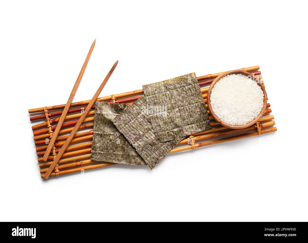 Bamboo mat with natural nori sheets, chopsticks and bowl of rice