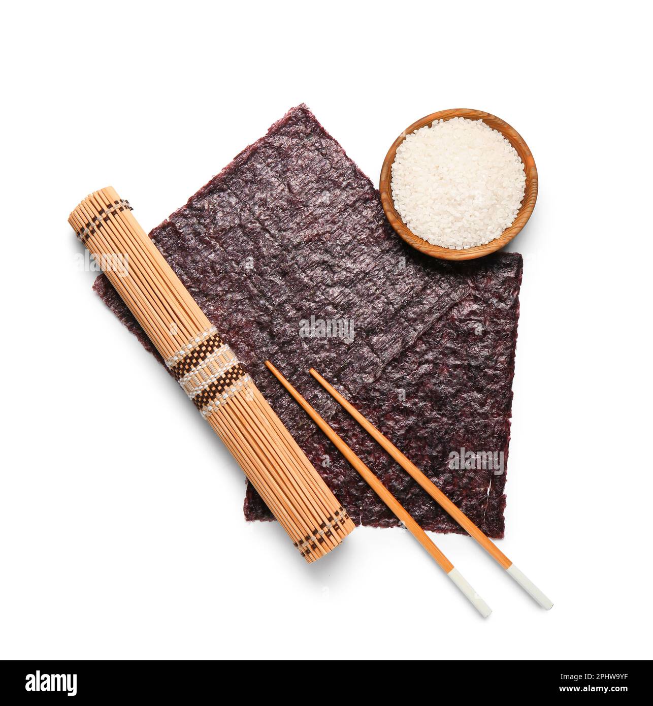 Bamboo mat, natural nori sheets, chopsticks and bowl of rice isolated