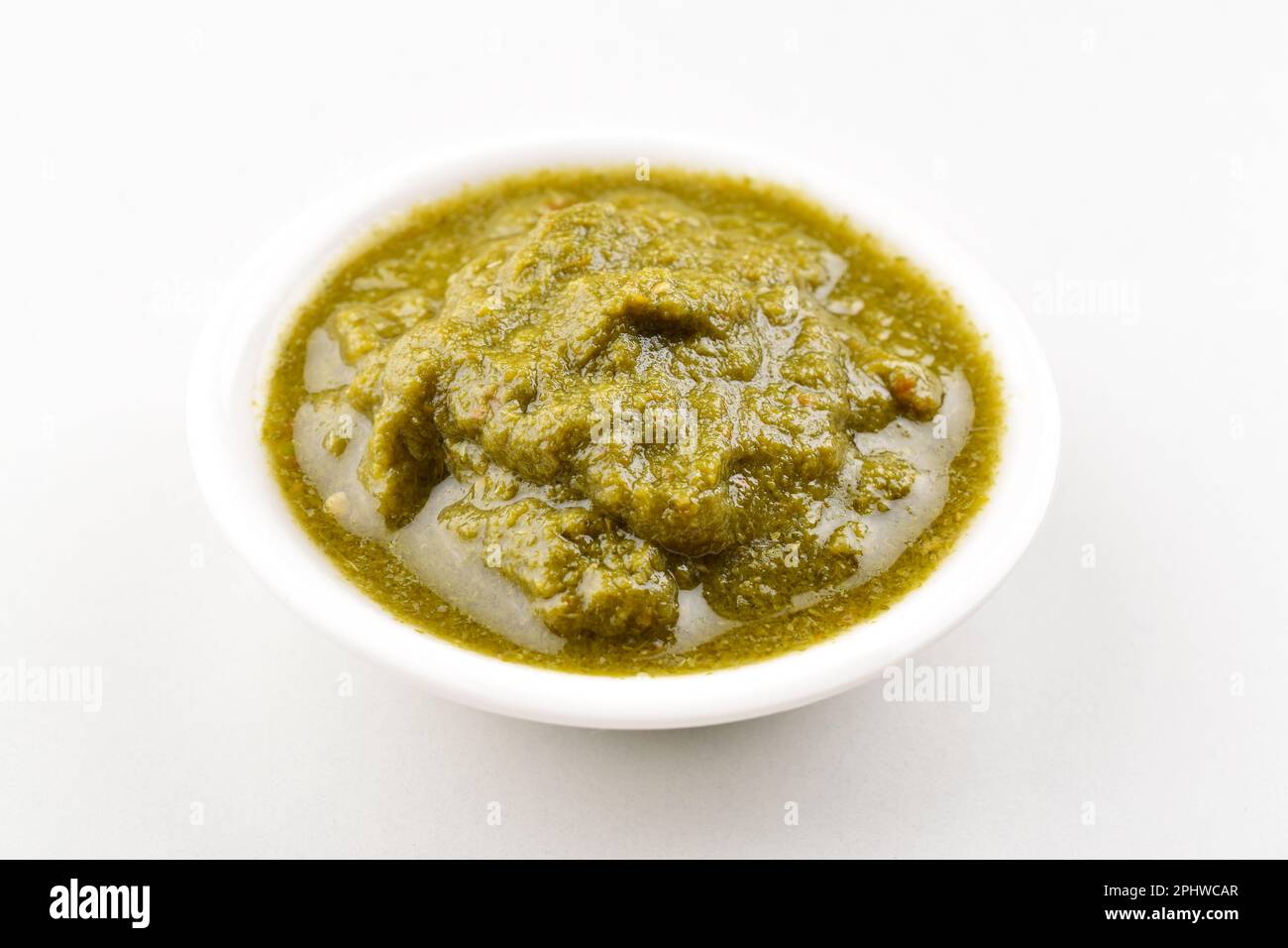Indian style green chutney in bowl on white background Stock Photo Alamy