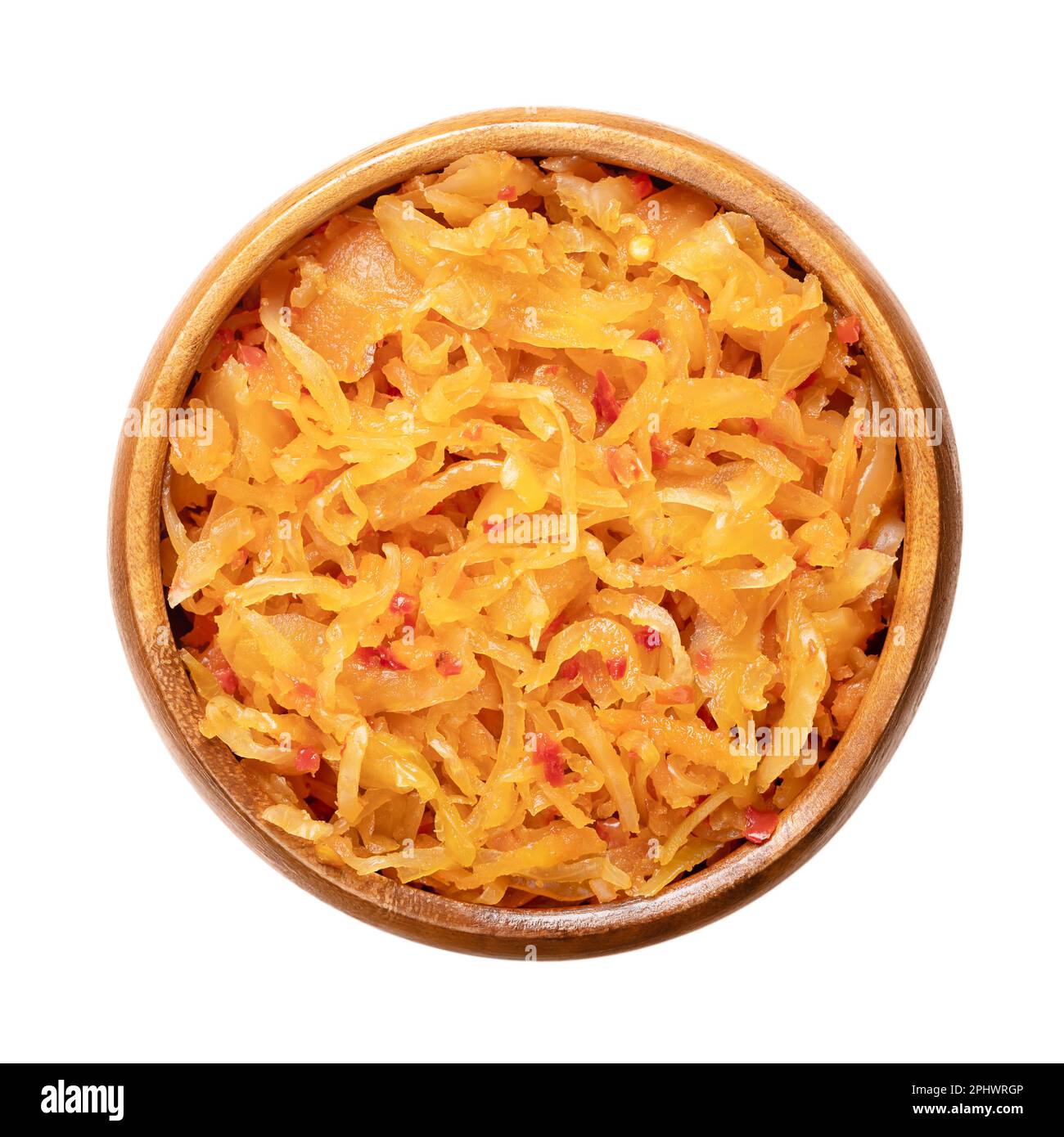 Kimchi, in a wooden bowl. Traditional Korean side dish of salted and fermented vegetables cabbage, carrots, radish and onions, and seasoned. Stock Photo