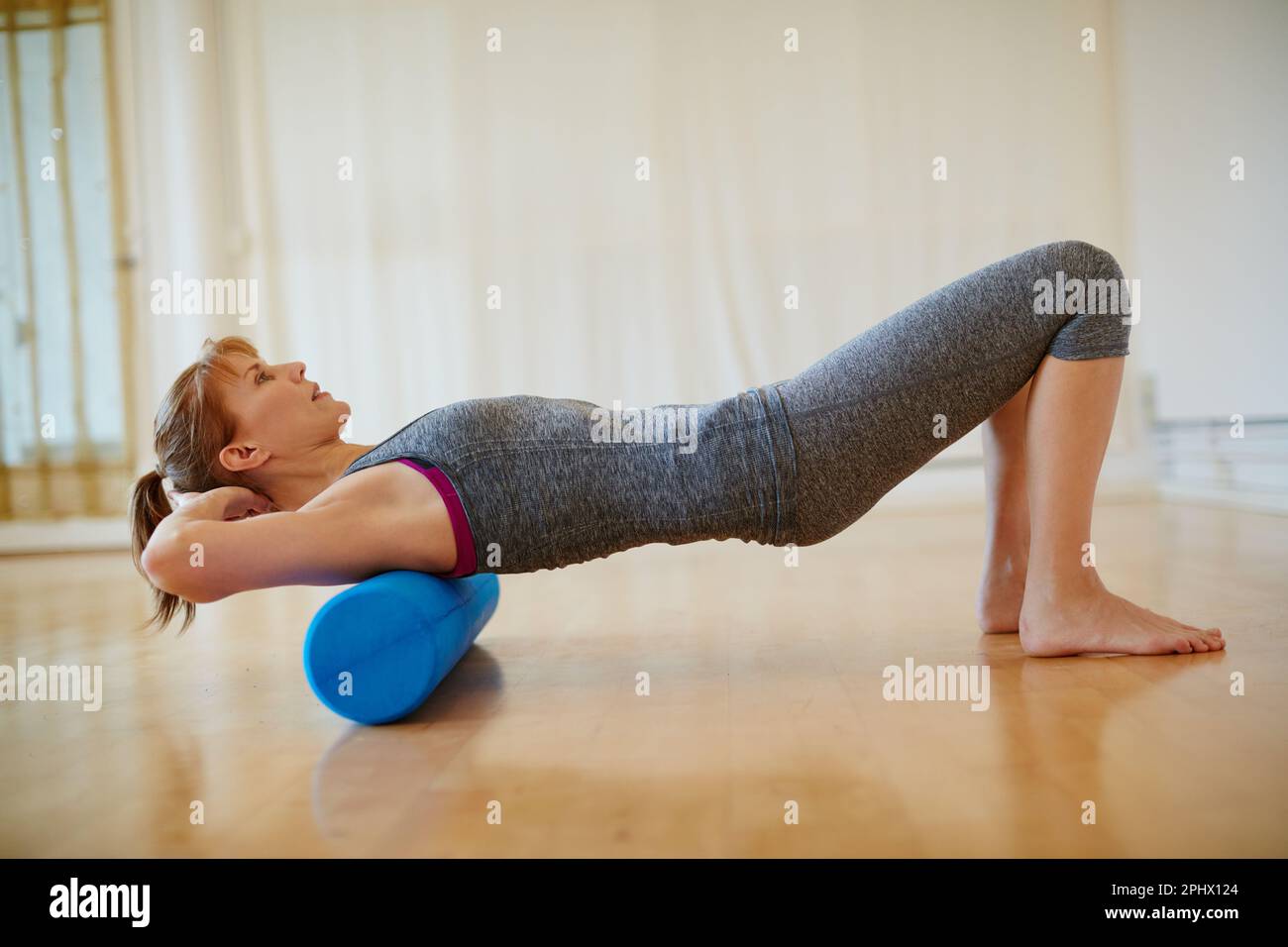 Keeping those muscles flexible and strong. a woman doing roller foam ...