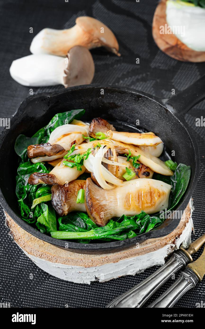 Grilled Pleurotus eryngii mushrooms with poached egg and spinach. Hot