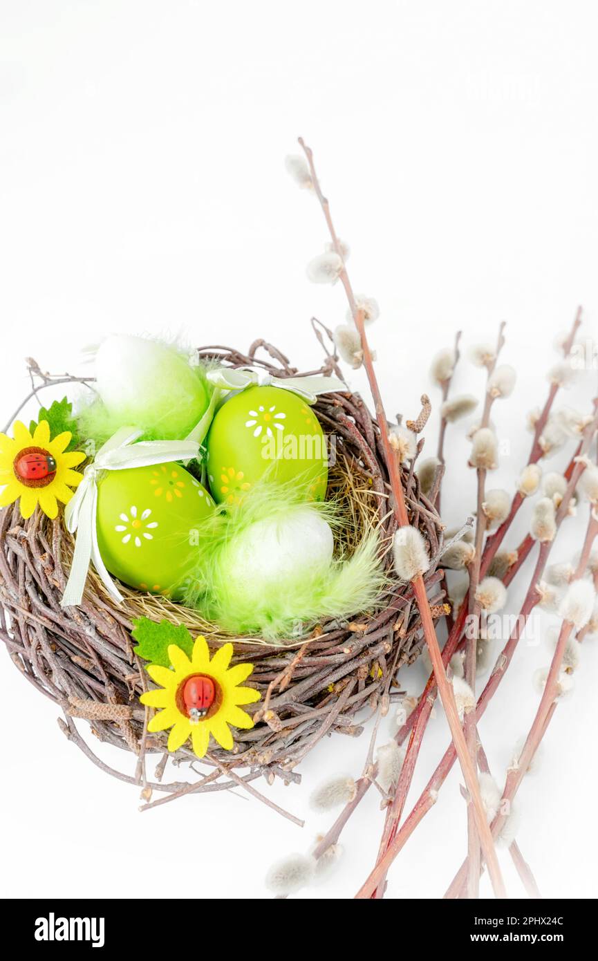 Easter still life. Easter decorated eggs in a nest with a bouquet of ...