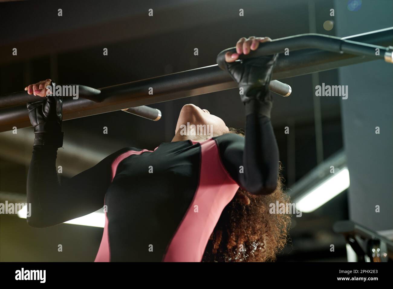 Ultimate strength. a young woman doing pull ups at the gym Stock Photo ...