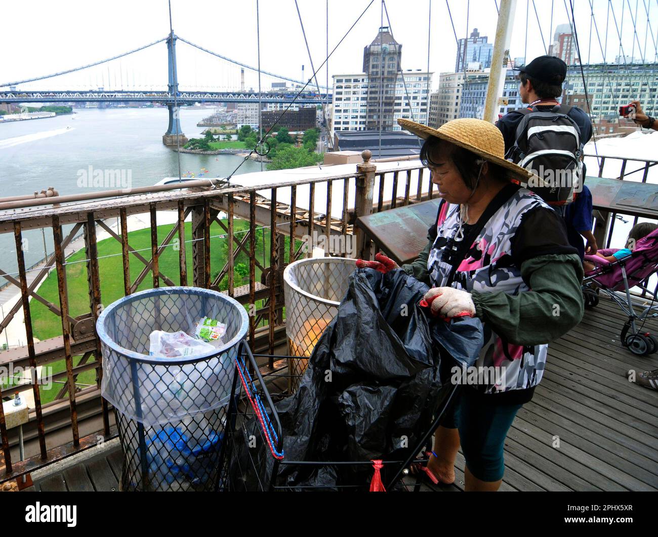 An American Chinese woman cleaning the bins on the Brooklyn Bridge, New